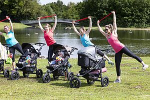 Mehrere Mamas beim Sport im Park - die Babys sind im Buggy dabei.