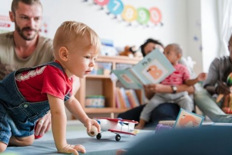 Spielende Kinder mit ihren Eltern in einer Eltern-Kind-Gruppe