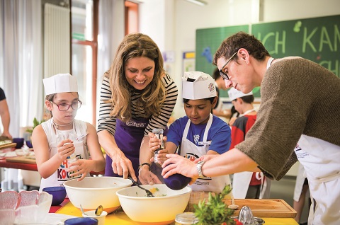 Kinder und Erwachsene kochen gemeinsam